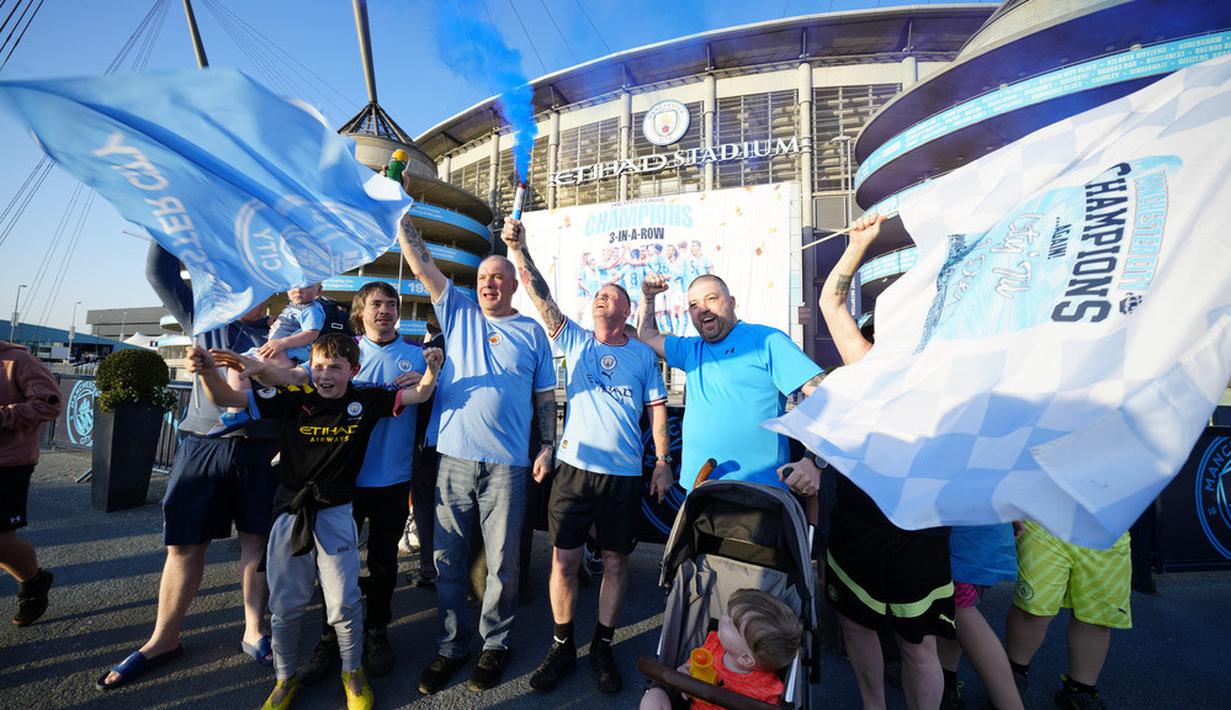 Sejumlah suporter Manchester City merayakan gelar juara Liga Inggris di depan Stadion Etihad, Sabtu (20/5/2023). City memastikan gelar juara setelah Arsenal dikalahkan Nottingham Forest dengan skor 0-1 pada lanjutan Liga Inggris 2022/2023 hari Minggu (21/05/2023). (AP Photo/Jon Super)