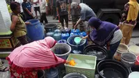 Sejumlah warga sedang menerima bantuan air bersih yang diberikan oleh Gibran Rakabuming Raka, Jumat (1/11).(Liputn6.com/Fajar Abrori)