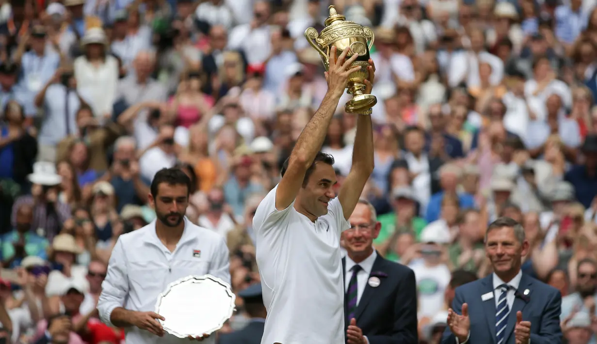Petenis Swiss, Roger Federer meraih trofi setelah mengalahkan petenis Kroasia, Marin Cilic pada pertandingan final tunggal putra Kejuaraan Wimbledon 2017 di Wimbledon, London. (16/07). Roger Federer menang 6-3, 6-1, 6-4. (AFP Photo / Daniel Leal-Olivas)