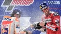 Pembalap Ducati, Andrea Dovizioso (kanan), berselebrasi dengan Marc Marquez setelah balapan MotoGP Aragon, Minggu (22/9/2019). (AFP/Javier Soriano)
