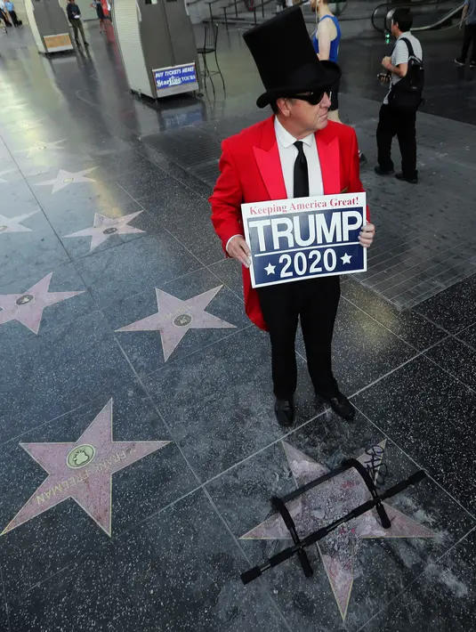 Gregg Donovan berdiri dekat bintang di Walk of Fame Hollywood atas nama Presiden AS Donald Trump yang rusak di Los Angeles, Rabu (25/7). Perusakan Hollywood Walk of Fame Donald Trump itu dilakukan seorang pria dengan menggunakan kapak. (AP/Reed Saxon)
