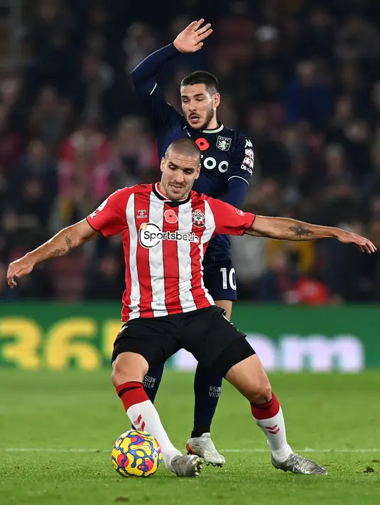 Gelandang Southampton Oriol Romeu (depan) ditekel oleh gelandang Aston Villa Emiliano Buendia pada laga lanjutan Liga Inggris 2021-2022 di Stadion St Mary’s, Sabtu (6/11/2021) dini hari WIB. Bermain di kandang sendiri, Southampton mampu menang tipis 1-0 atas The Villans. (Glyn KIRK / AFP)