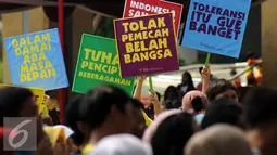 Peserta mengangkat tulisan saat perayaan Hari Perdamaian Internasional di Balai Kota Jakarta, Minggu (20/9/2015). Perayaan Hari Perdamaian Internasional diiringi dengan pembacaan Deklarasi Gerakan Perdamaian. (Liputan6.com/Helmi Fithriansyah)