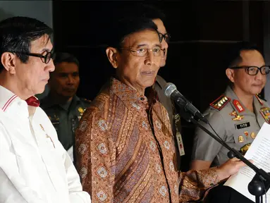 Menkopolhukam Wiranto (tengah) bersama Menkumham, Mendagri dan Kapolri menunjukkan surat pernyataan di Jakarta, Senin (8/5). Wiranto membacakan pernyataan pemerintah terkait pembubaran ormas Hizbut Tahrir Indonesia. (Liputan6.com/Helmi Fithriansyah)