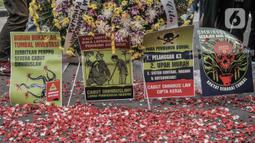 Massa buruh menaburkan bunga sebagai simbol duka atas kebijakan pemerintah di kawasan Patung Kuda, Jakarta, Senin (2/11/2020). Buruh dari berbagai serikat pekerja menggelar demo terkait penolakan pengesahan omnibus law Undang-Undang Cipta Kerja dan upah minimum 2021. (merdeka.com/Iqbal S Nugroho)