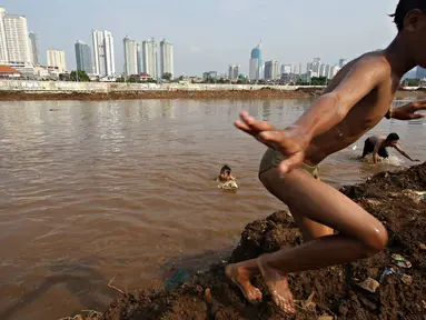 Anak-anak berenang di aliran air Kanal Banjir Barat, Jakarta, Kamis (26/11/2015). Dalamnya kali tidak menjadi penghalang bagi anak-anak tersebut untuk tetap bermain, meskipun berbahaya bagi keselamatan mereka. (Liputan6.com/Immanuel Antonius)