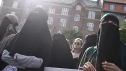 Demonstran melakukan protes larangan penggunaan cadar di Kopenhagen, Rabu (1/8). Parlemen Denmark mengesahkan undang-undang yang melarang pengenaan penutup muka bagi perempuan di tempat umum pada Mei 2018. (Mads Claus Rasmussen/Ritzau Scanpix via AP)