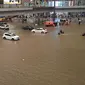 Sejumlah kendaraan melintasi banjir di sepanjang jalan setelah hujan lebat di Zhengzhou di provinsi Henan, China tengah (20/7/2021). Luapan sungai menggenangi jalan-jalan dan membuat kendaraan terbawa arus setelah curah hujan 200 mm turun dalam satu jam. (AFP/STR)