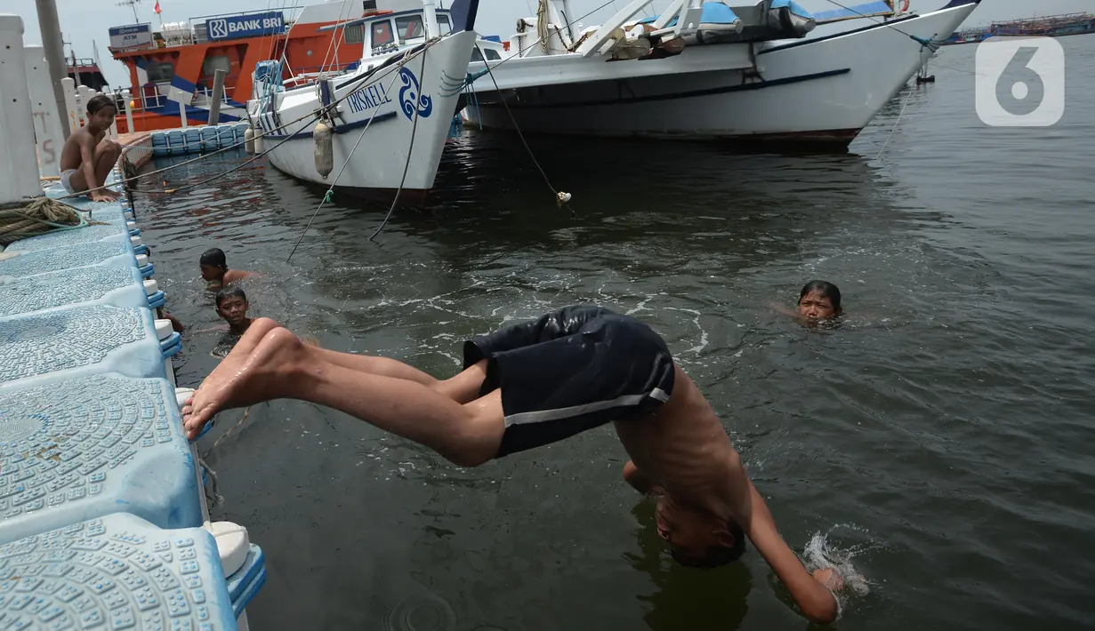 Anak-anak bermain di kawasan Muara Angke, Jakarta, Sabtu (10/4/2021). Minimnya lapangan dan taman-taman hingga kondisi laut yang terlalu kotor merupakan bentuk tak terpenuhinya hak-hak dasar anak-anak nelayan di Jakarta. (merdeka.com/Imam Buhori)