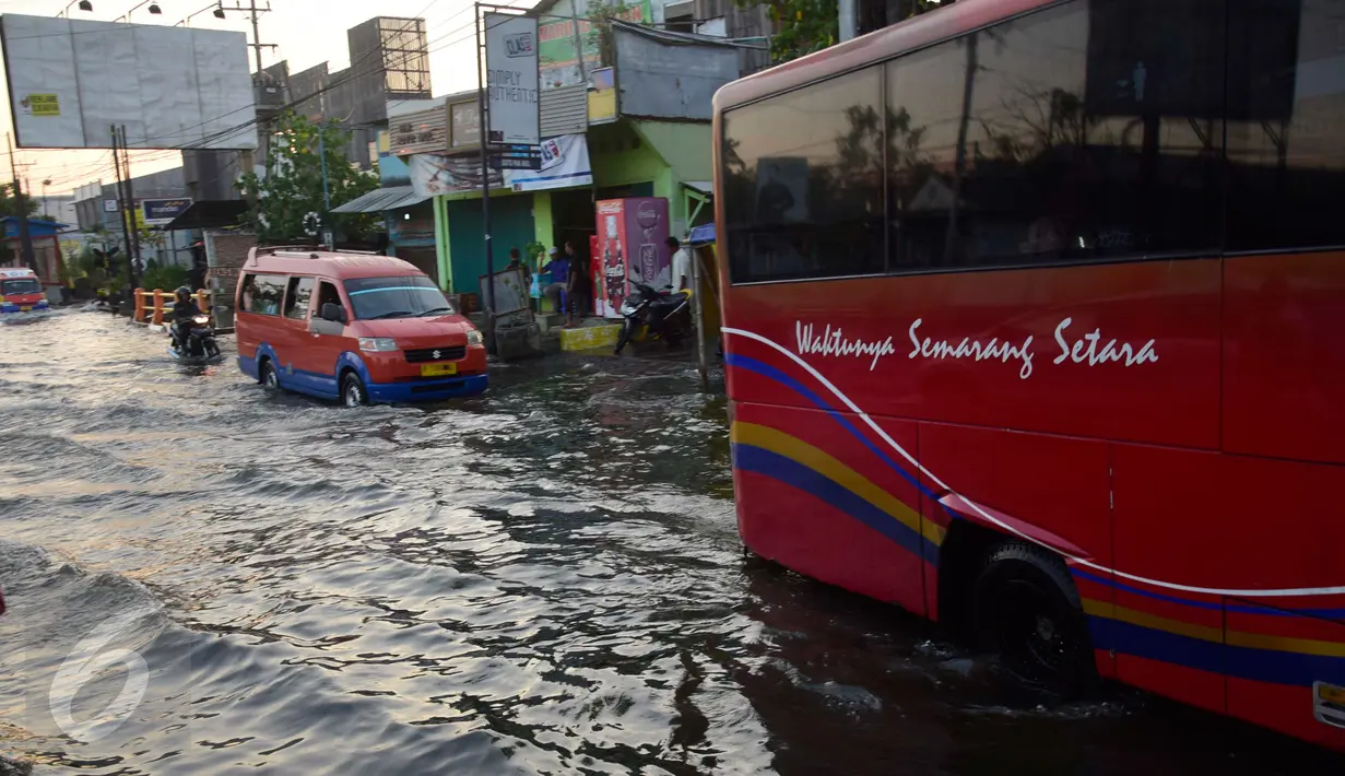 Sejumlah kendaraan melintasi jalan yang tergenang banjir rob di ruas jalur pantura Semarang-Demak ,Jawa Tengah, Minggu (12 /06/2016). Meski banjir yang cukup tinggi hanya kendaraan besar truk atau bus yang bisa melintas. (Gholib)