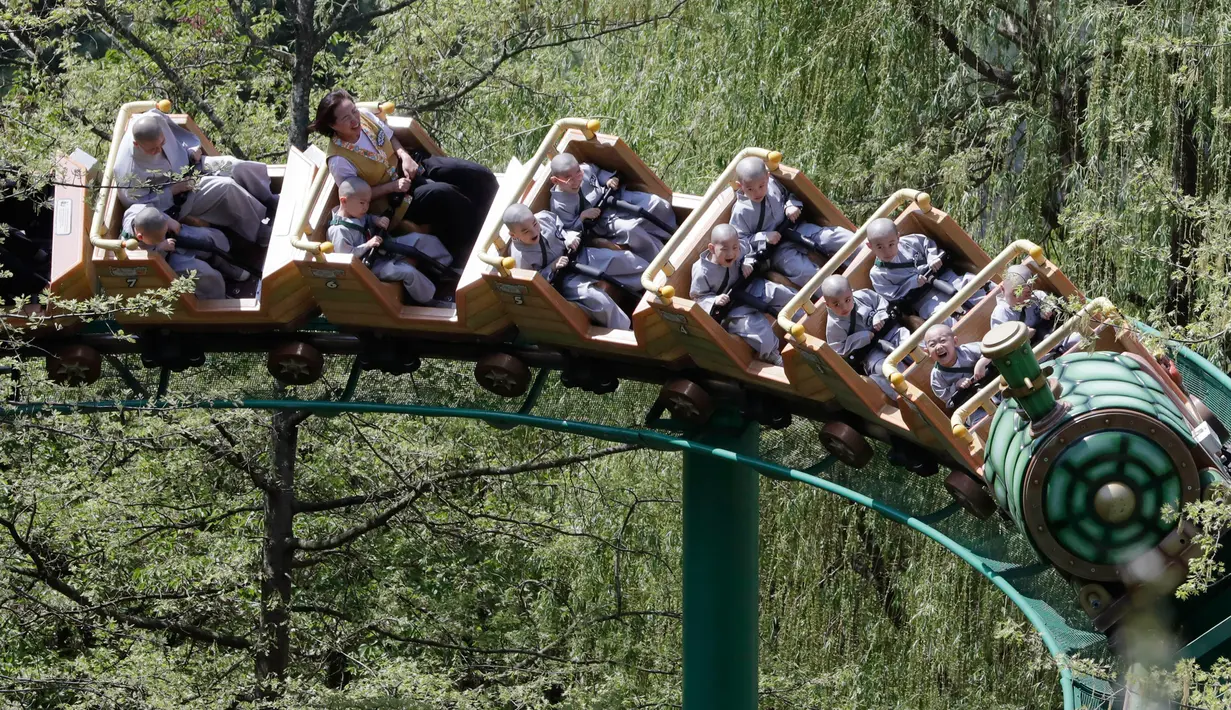 Para biksu cilik menaiki roller coaster saat mengunjungi taman hiburan Everland di Yongin, Korea Selatan, Kamis (2/5). Jelang perayaan ulang tahun Buddha pada 12 Mei, anak-anak di Korea Selatan akan menginap di kuil selama tiga minggu. (AP Photo/Lee Jin-man)