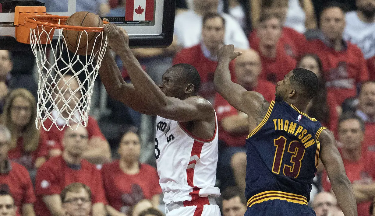 Pemain Raptors, Bismack Biyombo #8 melakukan slam dunk saat dihadang Tristan Thompson #13  pada laga final wilayah timur NBA playoffs 2016 di Air Canada Centrer (27/5/2016). Cavaliers menang 113-87. (Nick Turchiaro-USA TODAY Sports)