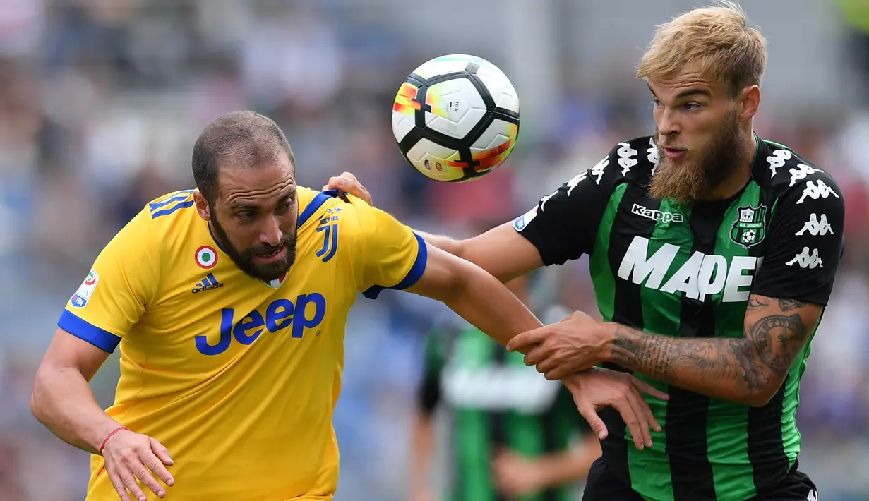 Duel pemain Juventus, Gonzalo Higuain (kiri) dengan pemain Sassuolo, Timo Letschert pada lanjutan Serie A di  Stadio Citta del Tricolore, Reggio Emilia, Italia (17/9/2017). Juventus menang 3-1. (AFP/Marco Bertorello)