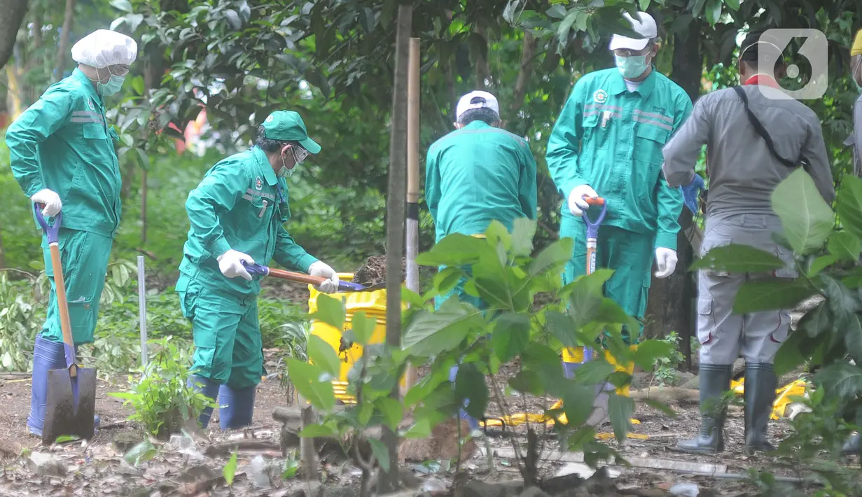 Petugas BATAN dan BAPETEN memasukkan tanah ke dalam drum saat proses dekontaminasi zat radioaktif di Perumahan Batan Indah, Tangerang Selatan, Minggu (16/2/2020). Petugas mengambil sisa-sisa tanah yang masih mengandung zat radioaktif untuk dibawa ke Batan guna diolah. (merdeka.com/Arie Basuki)