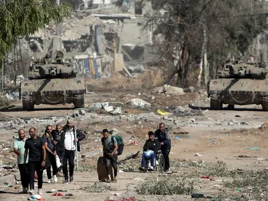 Warga Palestina melarikan diri ke Gaza utara saat tank-tank Israel memblokir jalan Salah al-Din di Jalur Gaza Tengah pada Jumat, 24 November 2023, saat gencatan senjata empat hari dalam perang Israel-Hamas dimulai sebagai bagian dari kesepakatan yang ditengahi oleh Qatar. (AP Photo/Mohammed Dahman)