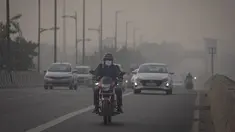 Seorang pengendara sepeda motor berkendara dengan menggunakan masker polusi di tengah kabut asap di New Delhi, India, Selasa (7/11/2023). (AP Photo/Altaf Qadri)