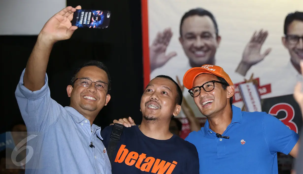 Cagub DKI Jakarta, Anies Baswedan (kiri) bersama Sandiaga S Uno berfoto dengan perwakilan pemuda saat melakukan tanya jawab di GOR Jakarta Timur, Rabu (4/1). Anies Sandi memaparkan rencana pembangunan sarana olahraga. (Liputan6.com/Helmi Fithriansyah)