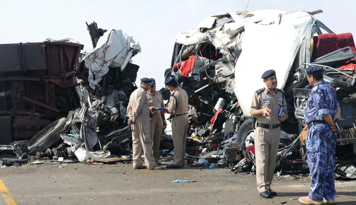 Petugas berada di lokasi kecelakaan yang melibatkan truk dan bus di jalan raya antara Ibri dan Fahud, Oman bagian barat, Selasa (1/3). Sebanyak 18 orang dari beberapa kewarganegaraan tewas dan 14 lainnya luka-luka. (STRINGER/Omani Police/AFP)