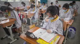 Siswa belajar dengan pemisah pada masing-masing meja mereka sebagai langkah pencegahan penyebaran COVID-19 di Sekolah Menengah No. 23 Wuhan, Wuhan, Provinsi Hubei, China, Rabu (6/5/2020). Sekitar 57.800 siswa tingkat akhir dari 121 SMA dan kejuruan di Wuhan kembali bersekolah. (Xinhua/Xiao Yijiu)
