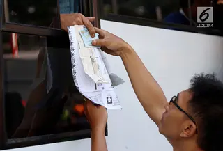Warga menyerahkan dokumen saat membayar pajak kendaraan bermotor di samsat keliling di car free day, Jakarta, Minggu (27/8). Layanan pembayaran pajak STNK bisa dilakukan tanpa membawa salinan atau BPKB. (Liputan6.com/Angga Yuniar)