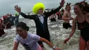 Warga Belgia berbondong-bondong menyerbu perairan Laut Utara untuk merayakan akhir pekan perrtama 2019 di Ostend, Sabtu (5/1). Tak sekadar bermain air, sebagian warga juga beraksi dengan kostum berwarna-warni. (AP/Francisco Seco)