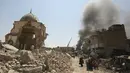 Warga sipil Irak melewati Masjid Agung al-Nuri yang hancur saat mengungsi dari Kota Tua di Mosul, 30 Juni 2017. Masjid yang dibangun pada abad ke-12 ini diledakkan ISIS pada 21 Juni 2017 sebagai upaya menghambat laju pasukan Irak. (AHMAD AL-RUBAYE/AFP)