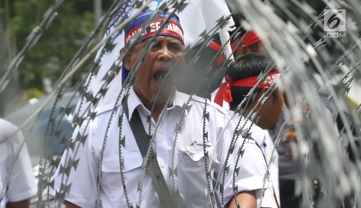 Serikat Pekerja Pertamina mengenakan ikat kepala dalam aksi damai di depan Istana, Jakarta, Selasa (19/2).  Dalam aksinya, mereka mengklaim bahwa harga avtur PT Pertamina (Persero) tidak berpengaruh pada mahalnya tiket pesawat. (Liputan6.com/Angga Yuniar)