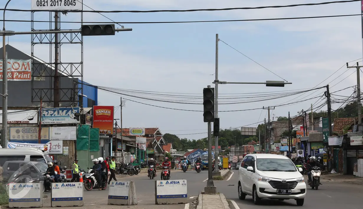 Kendaraan melintas di pertigaan Jatinangor, Sumedang, Jawa Barat, Sabtu (2/7). Mengatasi kepadatan kendaraan pemudik, petugas melakukan sistem pengalihan arus dengan menutup jalur dari arah Sumedang menuju Bandung Kota. (Liputan6.com/Immanuel Antonius)