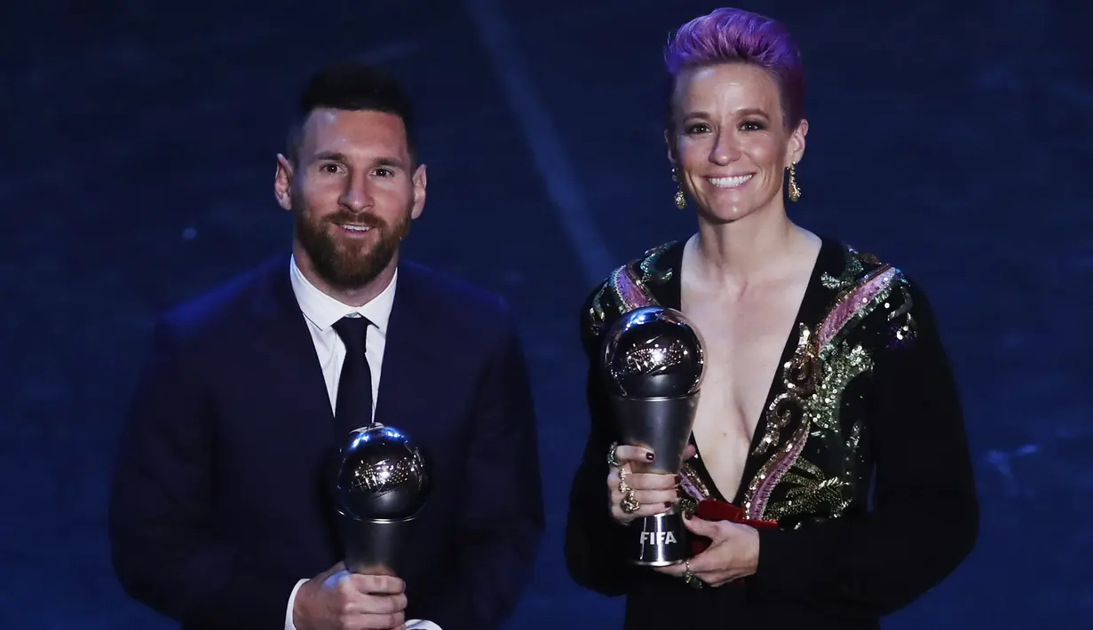 Penyerang Barcelona, Lionel Messi berpose dengan striker wanita Amerika Serikat, Megan Rapinoe usai menerima penghargaan Pemain Terbaik Dunia 2019 versi FIFA di teater La Scala Milan, Italia utara (23/9/2019). (AP Photo/Antonio Calanni)