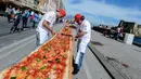 Sejumlah koki ahli berupaya mencetak rekor dunia dengan membuat pizza terpanjang di dunia, di sepanjang pinggir Laut Naples, Italia, 18 Mei 2016. Pizza itu memiliki ukuran sekitar 1 mil dan terbentang di sepanjang pinggir Laut Naples. (Mario LAPORTA/AFP)