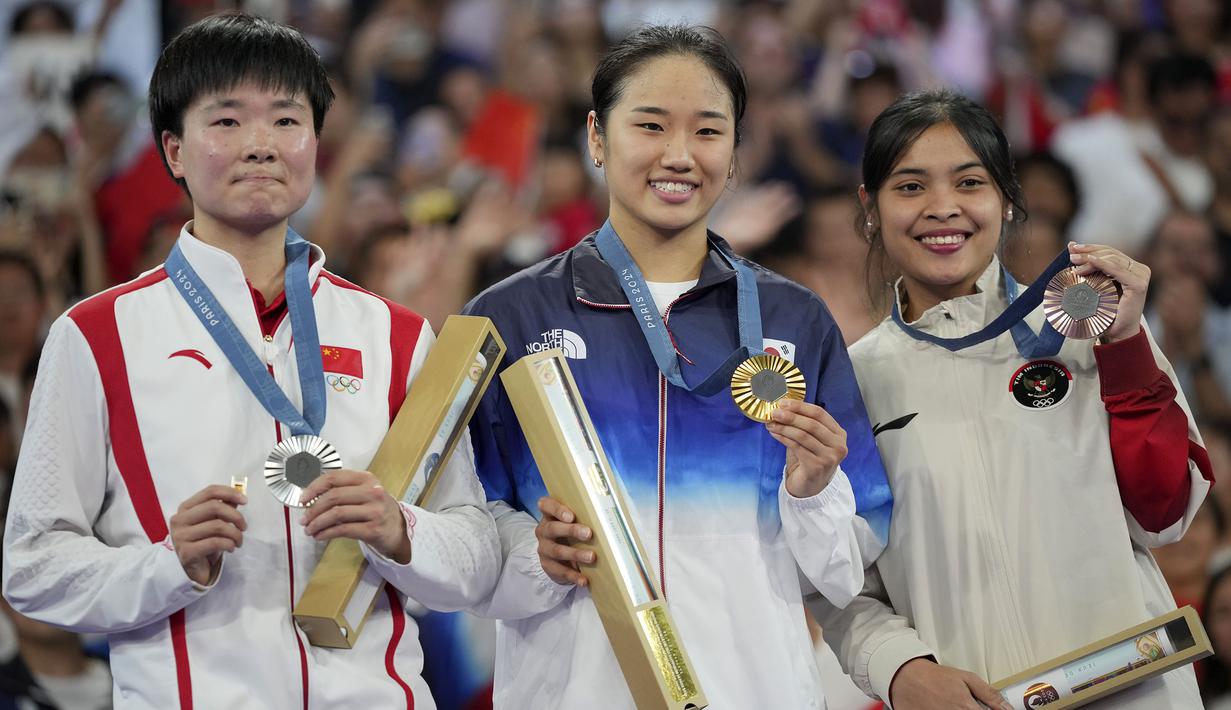 Pebulu tangkis tunggal putri China, He Bing Jiao (kiri) berfoto bersama dengan pebulu tangkis Korea Selatan, An Se-young dan pebulu tangkis Indonesia, Gregoria Mariska Tunjung di atas podium Olimpiade Paris 2024 setelah laga final yang berlangsung di Porte de la Chapelle Arena, Paris, Prancis, Senin (05/08/2024). (AP Photo/Kin Cheung)