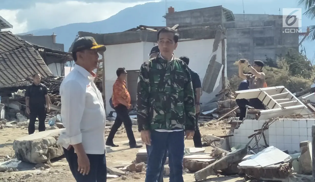 Presiden Joko Widodo (Jokowi) didampingi Menteri Koordinator Bidang Politik, Hukum,dan Keamanan Wiranto meninjau lokasi reruntuhan bangunan akibat gempa dan tsunami di Kota Palu, Sulawesi Tengah, Minggu (30/9). (Liputan6.com/Septian Deny)