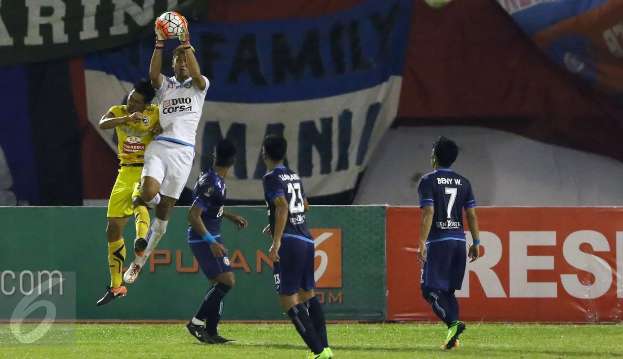Kiper Arema FC, Kurnia Meiga (kedua kiri) menangkap bola saat laga 8 besar Piala Presiden 2017 melawan Sriwijaya FC di Stadion Manahan, Solo, Minggu (26/2). Arema melaju ke semifinal setelah unggul 1-0. (Liputan6.com/Helmi Fithriansyah) 
