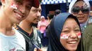 Calon penonton menghiasi muka dengan stiker bendera merah putih saat antre di sepanjang pendestrian Senayan untuk mengikuti Closing Ceremony Asian Games 2018, di Stadion GBK, Jakarta, Minggu (2/9). (merdeka.com/Arie Basuki)