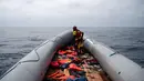Seorang anggota LSM Proactiva Open Arms Spanyol memeriksa perahu karet yang membawa pengungsi dan imigran tujuan Eropa di utara pantai Libya, Minggu (6/5). (AP Photo/Felipe Dana)