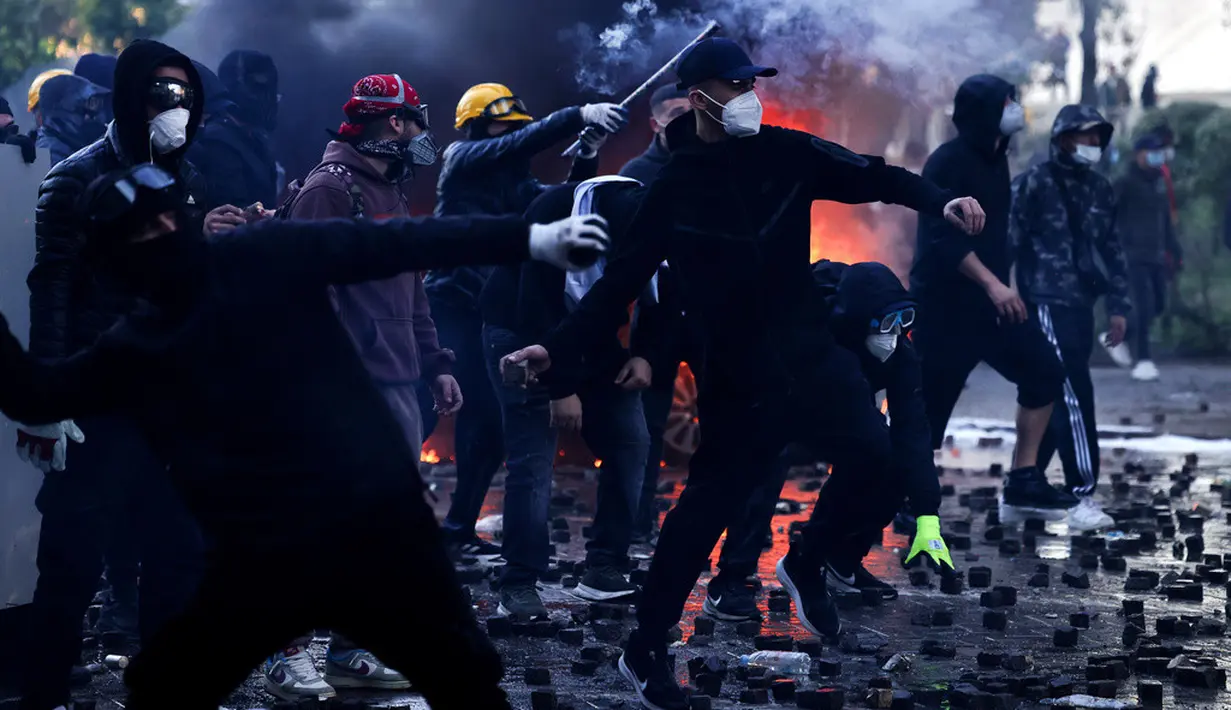 Sejumlah demonstran melempari polisi dengan batu saat aksi unjuk rasa antipemerintah di luar kantor Perdana Menteri di Tirana, Albania, Sabtu (17/10/2026). (AP Photo/Hameraldi Agolli)