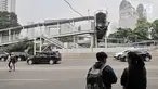 Pejalan kaki saat menunggu sepi lalu lintas sebelum menyeberang ke JPO Polda Metro Jaya, Jakarta, Selasa (8/5). Kondisi JPO Polda Metro Jaya sangat memprihatinkan karena hanya setengah alias buntung. (Merdeka.com/Iqbal Nugroho)