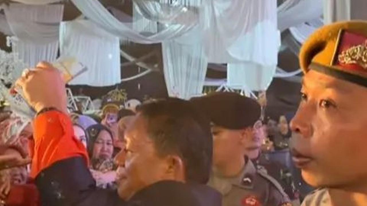 Meskipun para tamu terlihat berdesak-desakan untuk mendapatkan uang, suasana tetap berjalan aman karena ada pagar barricade yang membatasi mereka