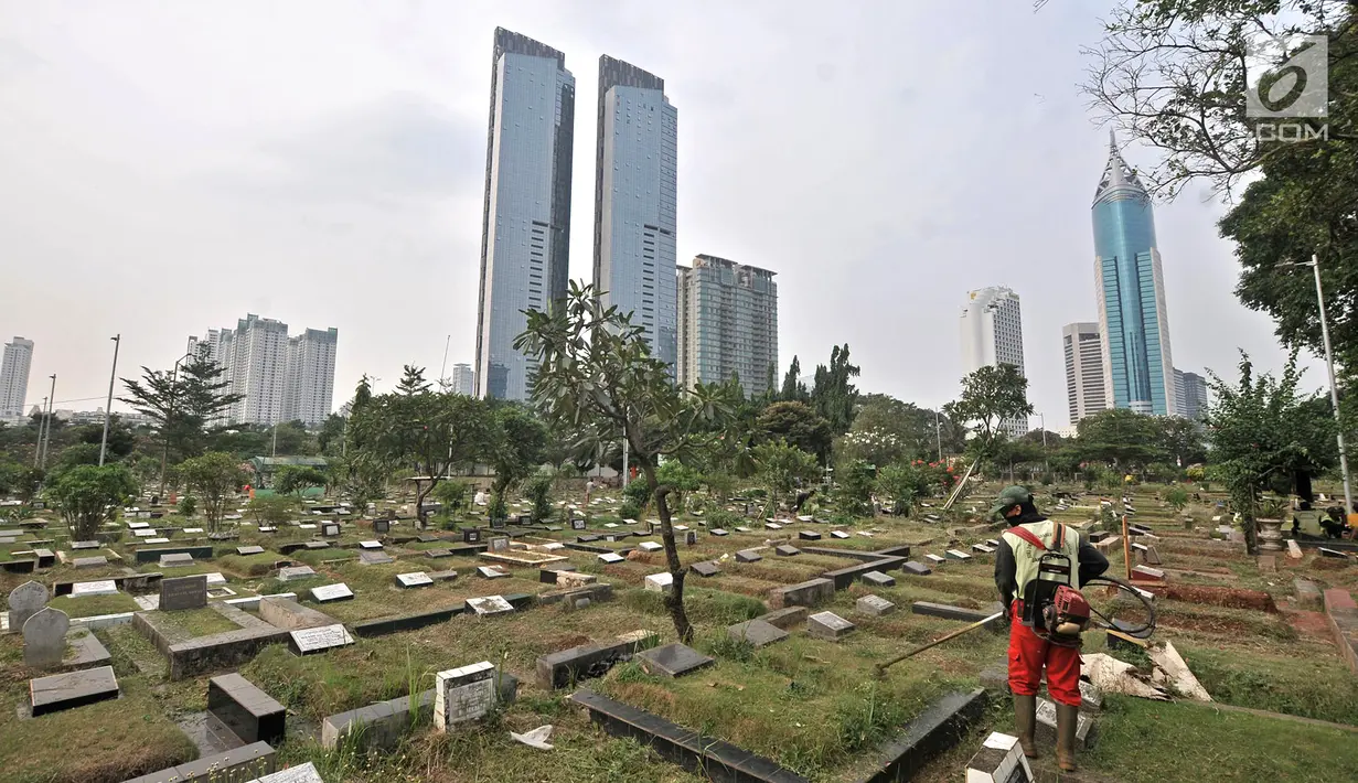 Petugas kebersihan memotong rumput makam di TPU Karet Bivak, Jakarta, Kamis (12/7). Kurang lebih 100 jenazah dimakamkan setiap harinya di wilayah Jakarta. (Merdeka.com/Iqbal Nugroho)
