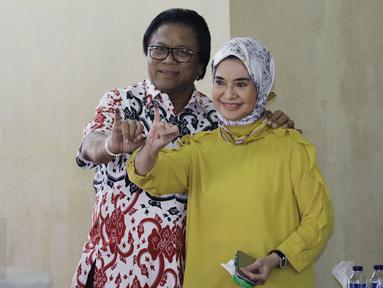 Ketua DPD RI Oesman Sapta Odang atau Oso di dampingi Istri Serviati Oesman menunjukan jarinya usai menggunakan hak pilihya dalam Pilkada Putaran kedua di TPS 03 Denpasar, Kuningan Timur, Jakarta, Rabu (19/4). (Liputan6.com/Johan Tallo)