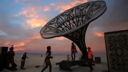 Peserta mengeksplorasi seni instalasi La Victrola dalam Festival Burning Man, yang digelar di padang pasir Black Rock, Nevada, Amerika Serikat. (01/09). Festival seni tahunan digelar 28 Agustus hingga 5 September 2016. (REUTERS/Jim Urquhart)
