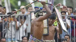 Dua pepadu (petarung) melakukan duel dalam kesenian tradisional peresean di Praya, Lombok Tengah, Selasa (19/2). Mereka bersenjatakan tongkat rotan (penjalin) dan berperisai kulit kerbau yang tebal dan keras (perisai disebut ende). (MOH EL SASAKY/AFP)