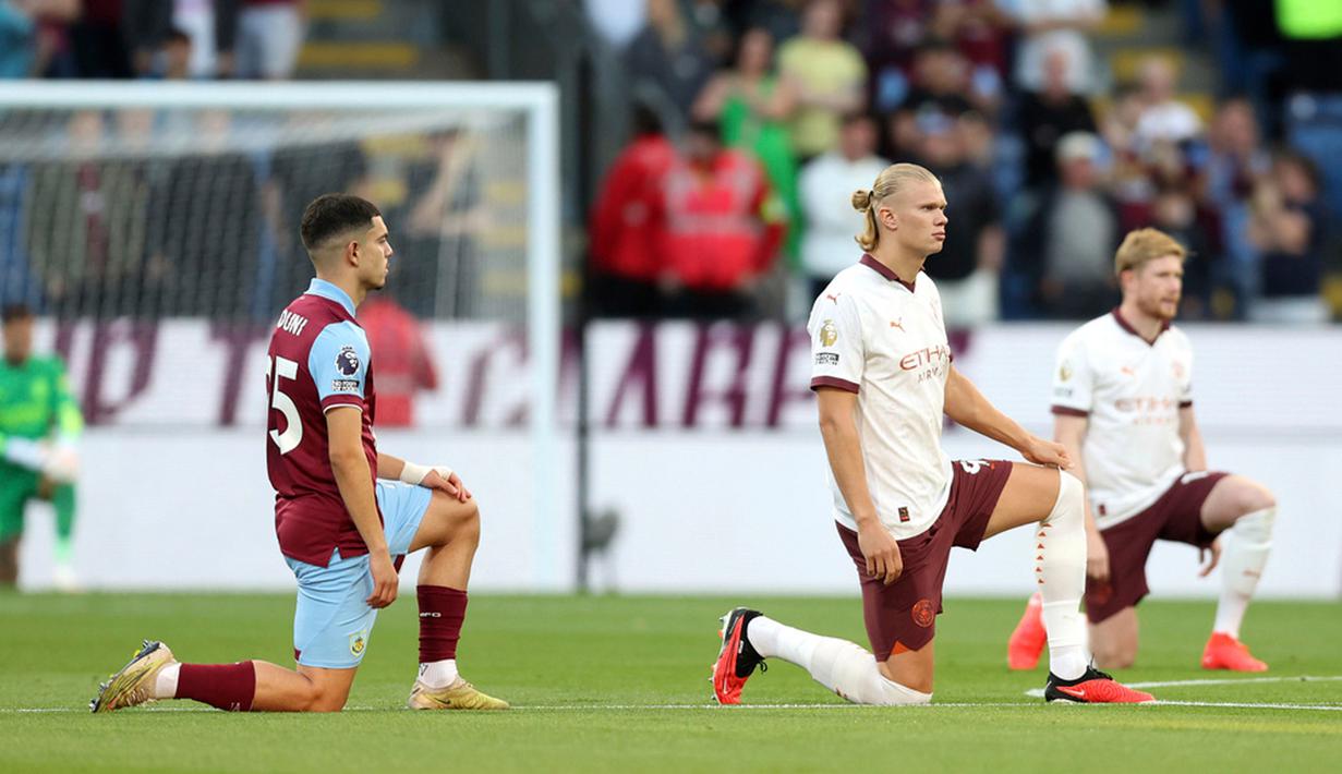 <p>Pemain Burnley Zeki Amdouni beserta pemain Manchester City Erling Haaland dan Kevin De Bruyne berlutut menjelang pertandingan sepak bola Liga Inggris di Turf Moor, Burnley, Inggris, Jumat (11/8/2023). Manchester City menang 3-0. (Nigel French/PA via AP)</p>