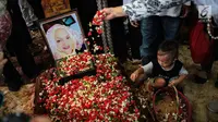 Cucu aktris senior Titi Qadarsih menaburkan bunga di pusara sang nenek saat pemakaman di TPU Tanah Kusir, Jakarta, Selasa (23/10). Sempat dirawat di Rumah Sakit Fatmawati, Titi Qadarsih meninggal saat dalam perjalanan pulang. (Liputan6.com/FaizalFanani)