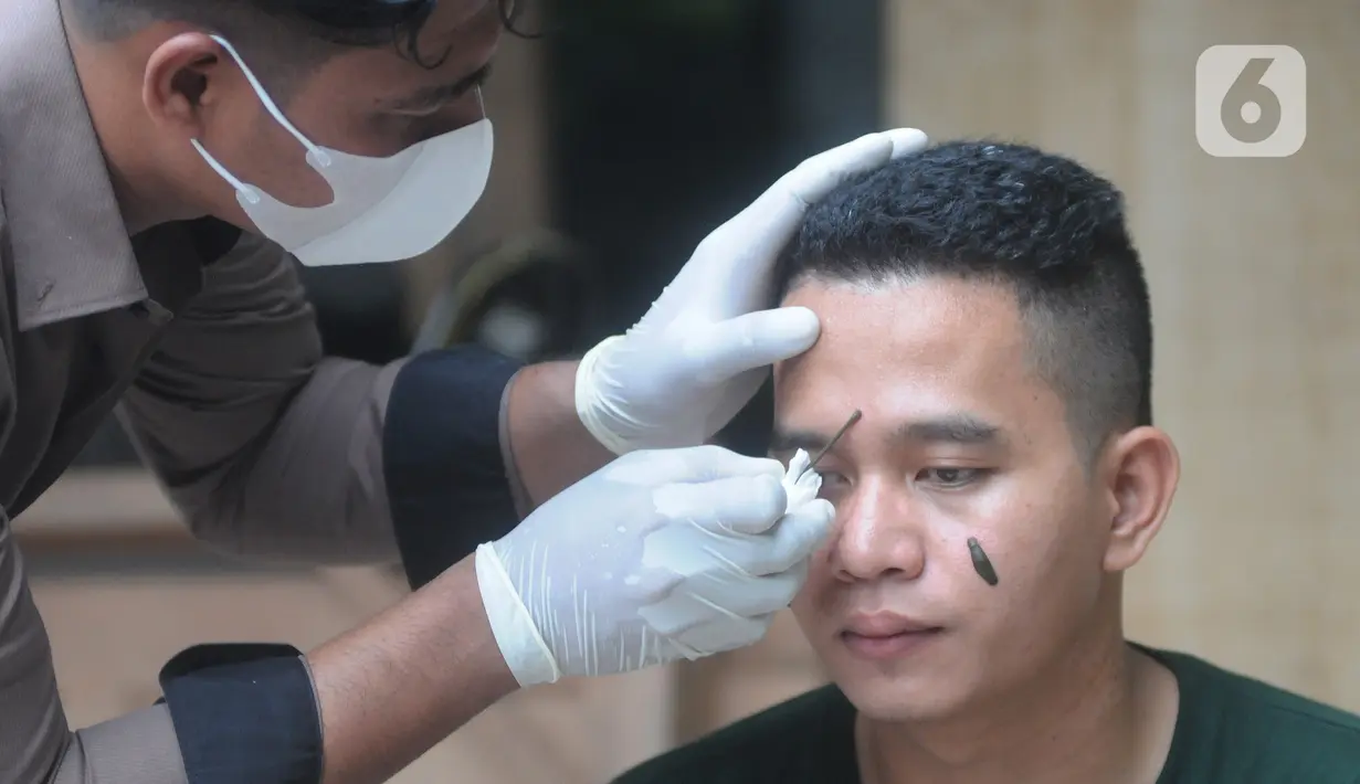 Peternak menaruh lintah di wajah seorang pria di pengobatan mutahir adopsi zaman kuno di Bedahan Depok, Jawa Barat, Senin (1/3/2021). Dalam sebulan peternak mampu meraih  rata-rata pendapatan  Rp 20 juta/bulan. (merdeka.com/Arie Basuki)