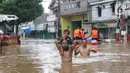 Warga melintasi banjir di perumahan Ciledug Indah, Tangerang, Rabu (1/1/2020). Banjir setinggi dada orang dewasa terjadi akibat meluapnya kali angke. (Liputan6.com/Angga Yuniar)