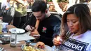 Will Halverson (kiri) merokok dari sebuah bong ketika Mimi Bui menyalakan ganja sehari sebelum pembukaan resminya di Lowell Cafe di Hollywood Barat, California  (30/9/2019).  Pengunjung dapat merokok ganja di kafe dengan menggunakan sendi, pipa, dan bong. (AFP Photo/Frederic J. Brown)