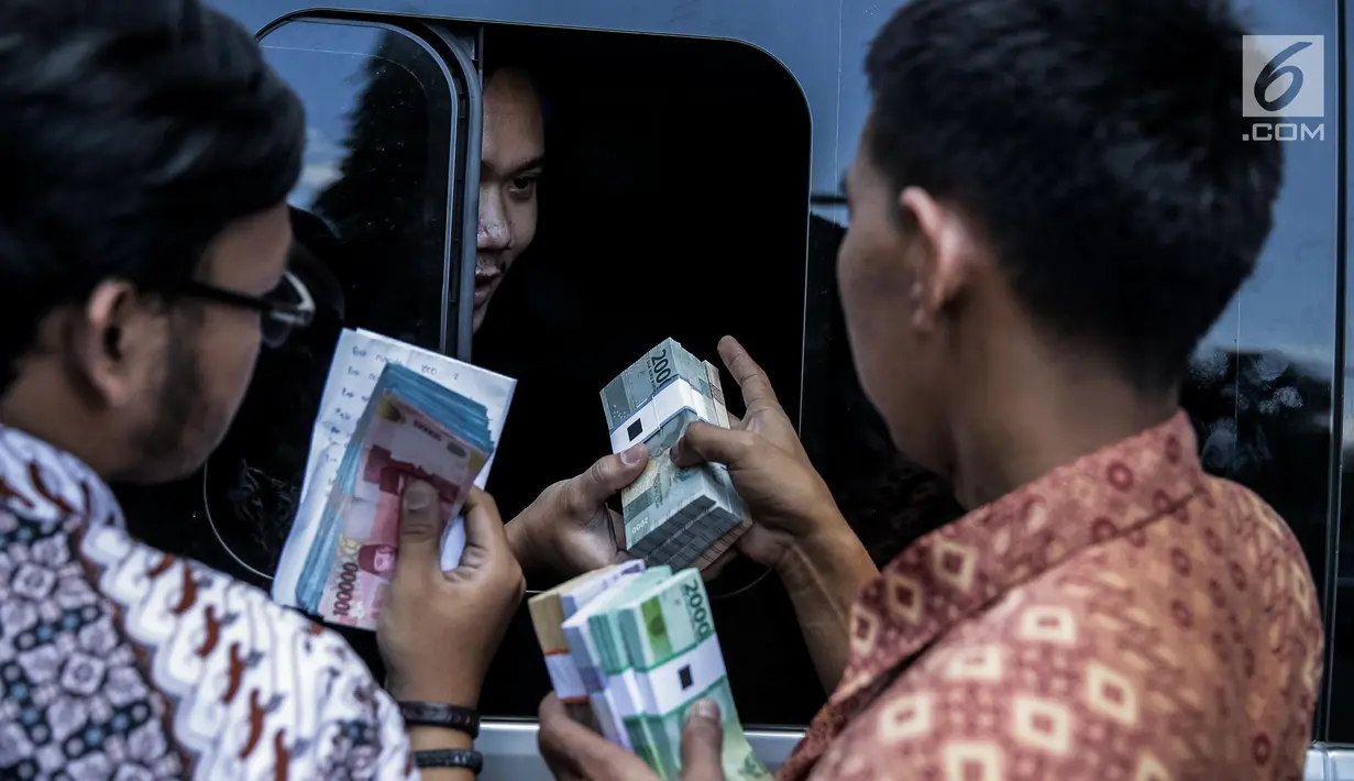 Petugas melayani transaksi penukaran uang pecahan ribuan dan puluhan ribu di kantor KKP, Jakarta, Jumat (16/6). Persediaan tersebut lebih tinggi dari perkiraan kebutuhan uang kartal saat Idul Fitri sebesar Rp167 triliun. (Liputan6.com/Faizal Fanani)