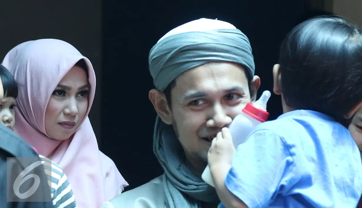 Ustadz Guntur Bumi (UGB) menggendong anaknya usai mengisi sebuah acara di kawasan Tendean, Jakarta, Rabu (16/11). UGB mengaku kurang komunikasi kepada istrinya dan kini berusaha untuk memperbaikinya. (Liputan6.com/Herman Zakharia)
