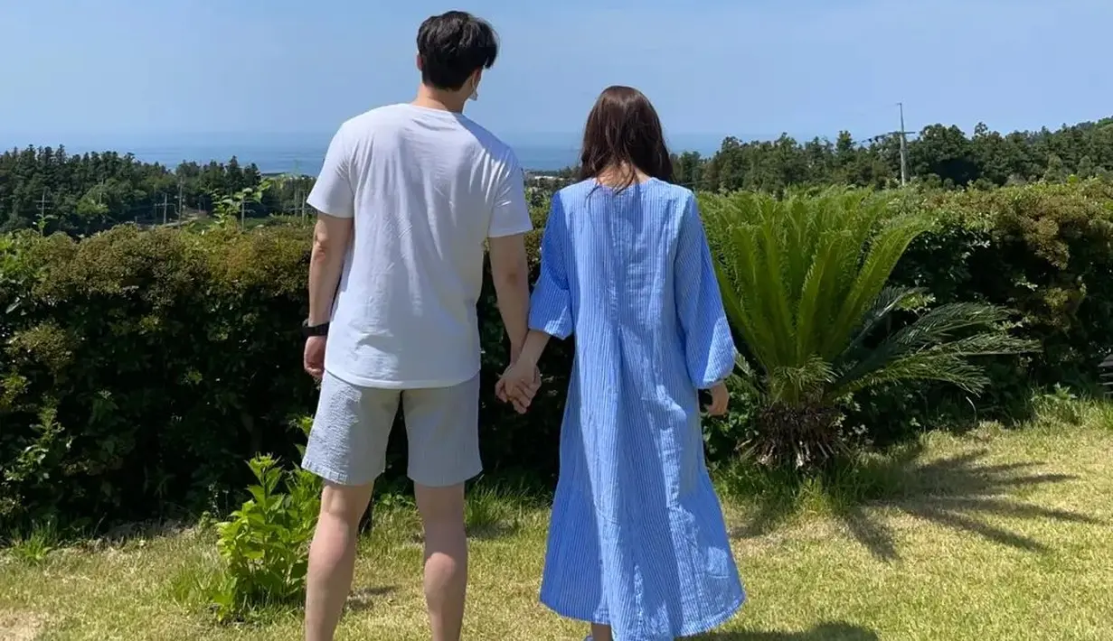 Shim Hyung Tak dan Hirai Saya bergandengan tangan dengan gambaran langit yang begitu biru dan cerah. "I will live happily ever after," tulis sang aktir sebagai keterangan fotonya. (Foto: Instagram/ tak9988)